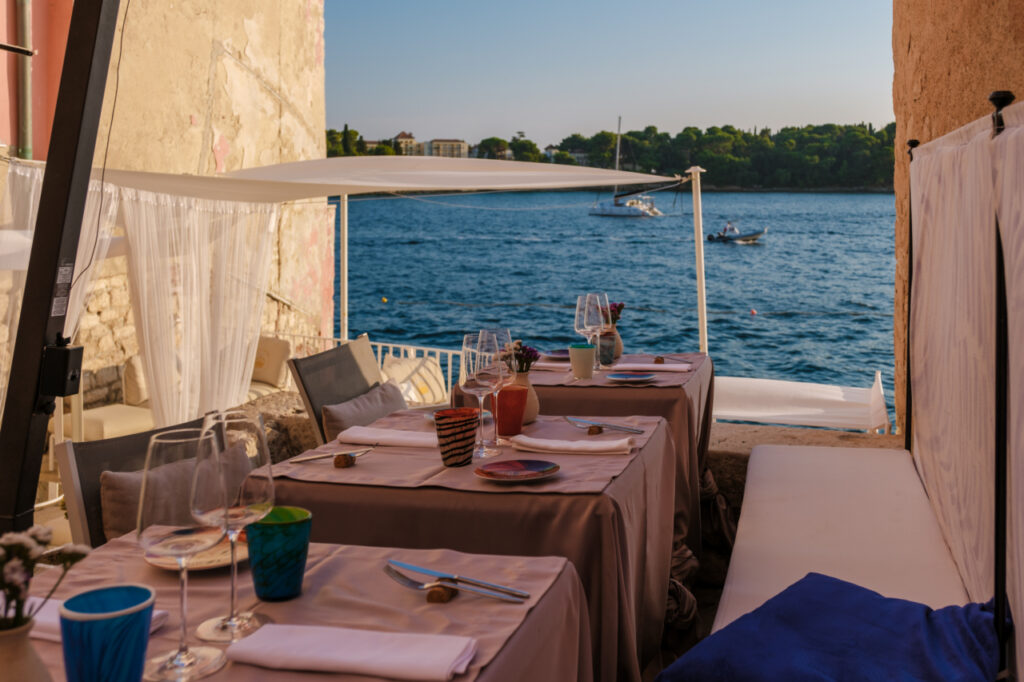 Dining by the Adriatic Sea in Rovinj, Croatia, as the sun sets over the tranquil waters